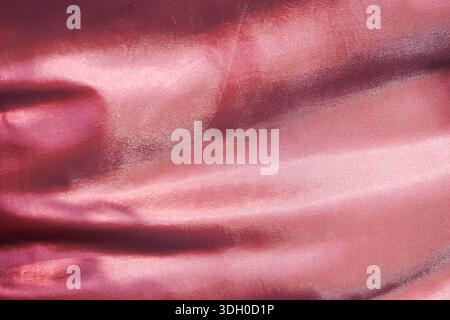 Elegant pink satin texture with smooth shiny fold and soft wave pattern creating abstract luxurious background with romantic or fashion style feeling Stock Photo