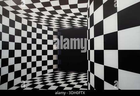 Abstract black and white checkered room creating strong optical illusion with geometric perspective, empty interior space designed for modern art back Stock Photo