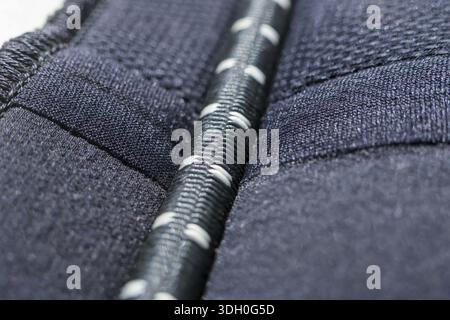 Macro closeup of dark textile fabric material with rough texture and white stitched cord expressing durable and industrial feeling showing detailed wo Stock Photo