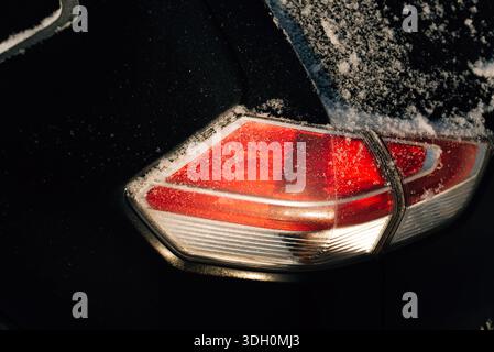 Taillight of a black car with snow Stock Photo