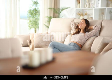 Woman relaxing sitting on a couch at home Stock Photo