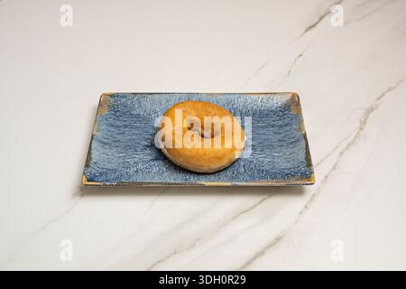 Extreme close-up of a traditional anise donut, split open to reveal its airy, soft crumb, contrasting with the shiny, smooth layer of white sugar cove Stock Photo