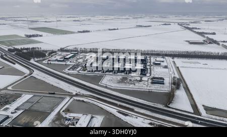 Aerial view of a sprawling data center complex surrounded by snow-dusted fields and waterways under a grey sky, Datacenter, Noord-Holland, Netherlands Stock Photo