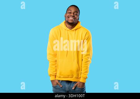 Happy African Guy Posing With Hands In Pockets, Blue Background Stock Photo