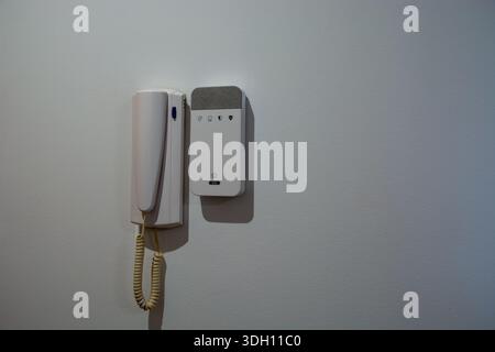 Wall mounted intercom handset and home alarm control panel. Concept of home security, safety systems, access control, and modern residential protectio Stock Photo
