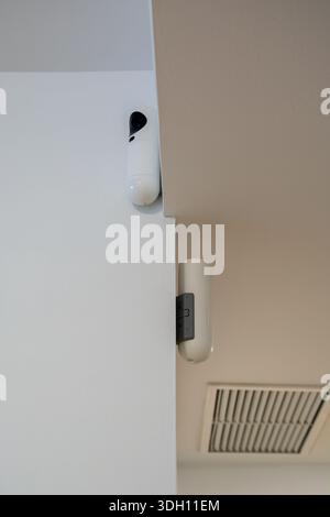 Surveillance cameras installed on an indoor wall as part of a home alarm system. Concept of home security, monitoring, safety, and residential protect Stock Photo