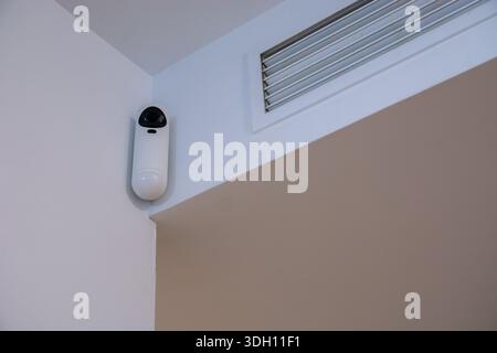 Surveillance cameras installed on an indoor wall as part of a home alarm system. Concept of home security, monitoring, safety, and residential protect Stock Photo