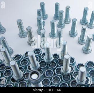 Metal bolts and hex nuts arranged on flat surface low angle view Stock Photo