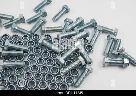 Metal bolts and hex nuts arranged on flat surface low angle view Stock Photo
