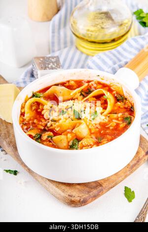 Warming comfort food, tasty chicken Lasagna Soup with tomato sauce, ground chicken meat fillet, grated cheese and wide lasagne pasta sheets Stock Photo