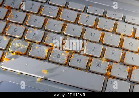 Close up of a dirty computer keyboard caused by careless snacking of cheese puffs, 2026, United States Stock Photo