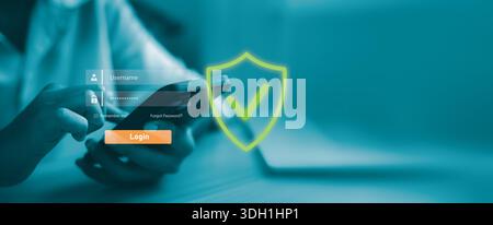 Hand holding smartphone with virtual login interface and security shield icon. Mobile cyber security, user authentication, data protection and safe di Stock Photo
