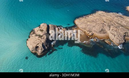 Aerial view of rugged granite outcrops meet the turquoise embrace of the ocean, creating a stunning contrast of textures and tones, Esperance, Western Stock Photo