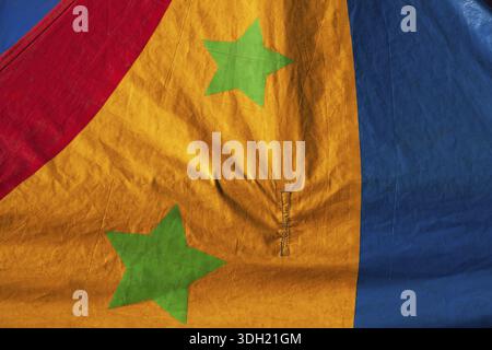 Close-up of two green stars on dyed red, yellow and blue canvas cloth material, Quebec, Canada Stock Photo