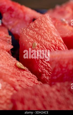 sliced flesh of ripe red juicy sweet watermelon, pieces of juicy red watermelon stacked together on a plate Stock Photo