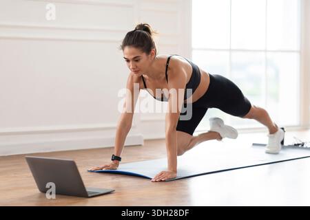 Focused Woman Doing Cross Body Mountain Climbers Exercise Stock Photo