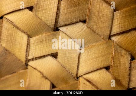 Close up of a traditional yellow woven texture, showing a detailed diagonal interlocking pattern, perfect for natural craft and background themes. Stock Photo