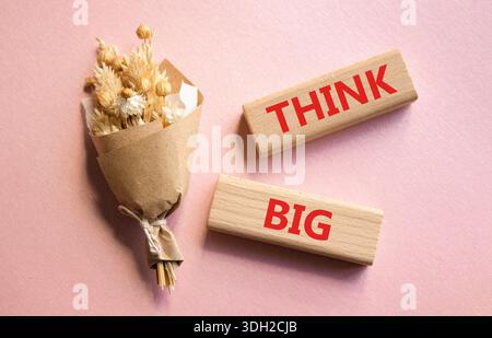 Think big symbol. Wooden blocks with words Think big. Beautiful pink background. Business and Think big concept. Copy space. Stock Photo