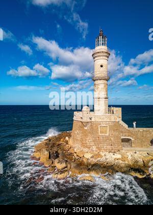 Aerial view of the Venetian Lighthouse of Chania standing tall against the azure sky and the deep blue sea, its stone weathered by time and sea spray, Stock Photo
