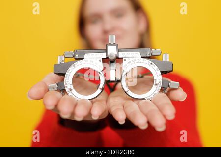 Closeup of trial frame for refraction testing and poor vision correction in ophthalmology optics concept on yellow background Stock Photo