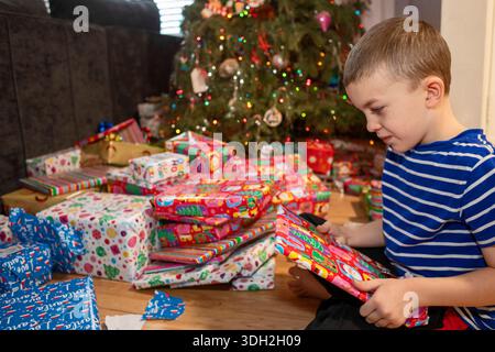 Denver, Colorado - A boy opens Christmas presents on Christmas morning. Stock Photo