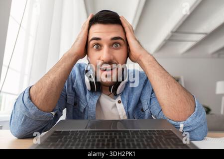 Surprised man having video call using laptop Stock Photo