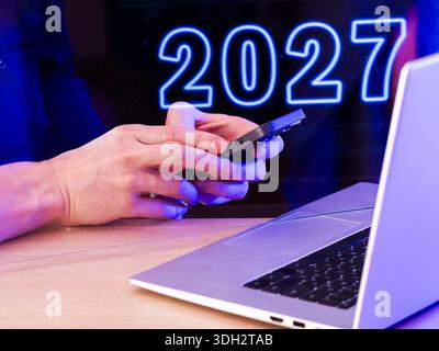 Image not fully accessible; assumed variant: close-up of typing and holding phone with glowing background. Stock Photo