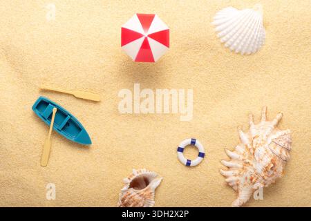 Trendy sunlight summer background made with sea shells and summer things on sand background. Minimal summer concept. Stock Photo