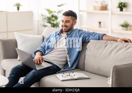 Smiling jewish man watching video on computer Stock Photo