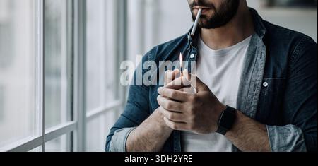 stressed cigarette Frustrated stressed young man smoking cigarette, unhealthy habits and  tobacco addiction Stock Photo