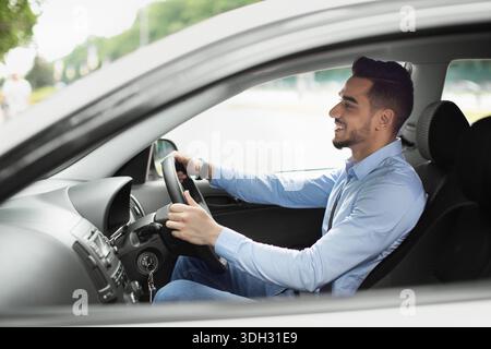Attractive arabic guy enjoying driving, going to job Stock Photo