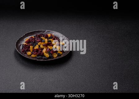Dried cranberries, yellow and black sweet raisins as ingredients for granola and breakfast. Raisins and cranberries as a food background for your desi Stock Photo