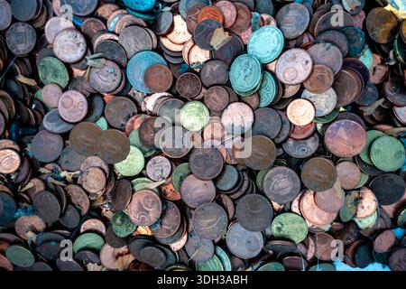 A detailed overhead view of a massive pile of dirty, tarnished Euro coins mixed with debris, illustrating themes of wealth, clutter, and currency. Stock Photo
