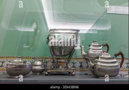 Biscainhos museum. Braga. An elegant silver tea and coffee service featuring an ornate hot water urn and matching pots displayed behind glass in a mus Stock Photo