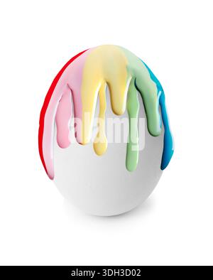 Colorful paint dripping down egg on white background. Easter celebration Stock Photo