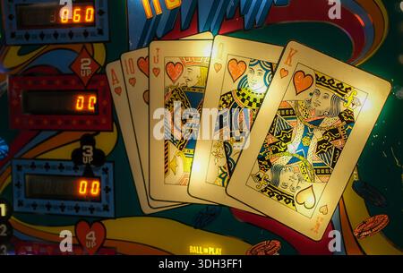 Playing card graphics and electronic score counters on pinball machine backglass. Stock Photo