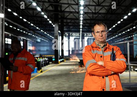 Portrait of technician oversees metal fabrication during production in workshop, highlighting heavy labor. Automation development and job responsibilities within manufacturing facility. Stock Photo