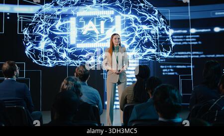Female CEO presenter gives AI concept speech featuring ai assistant and automation, engages investors and team during forum in futuristic auditorium. Artificial intelligence discussion. Stock Photo