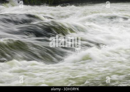 A close-up of the churning rapids of the River Nile in Jinja, Uganda, highlighting the powerful currents, frothy white water, and dynamic flow of Afri Stock Photo