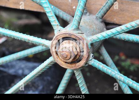 Rusty Metal Wheel Hub with Turquoise Spokes Close-Up Stock Photo