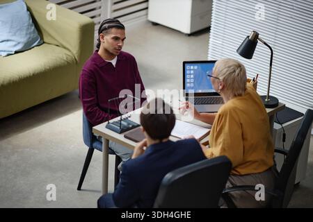 Young Black Man Attending Job Interview with Two Middle Aged Caucasian Professionals Stock Photo