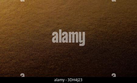 A luxurious dark golden background featuring a fine grainy texture and soft glow in the top-right corner. Elegant moody metallic surface is perfect fo Stock Photo
