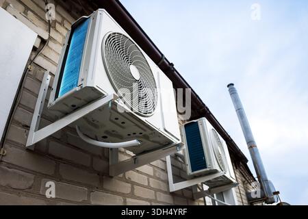 Outdoor two split air conditioning units mounted on siding wall. Stock Photo