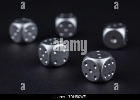 five silver dice view from above on black background. Stock Photo