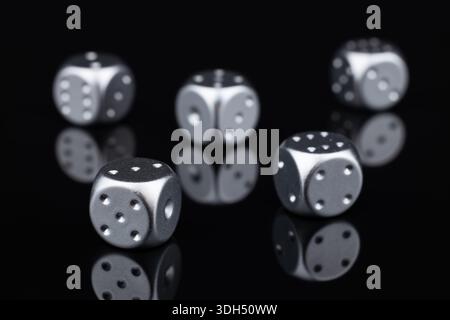 five silver dice view from above on black background. Stock Photo