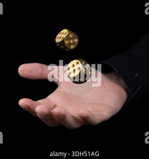 hand throwing two golden dice in the air on black background. Game with dice Gambling luck concept: bet, risk, have luck, win. lucky Stock Photo