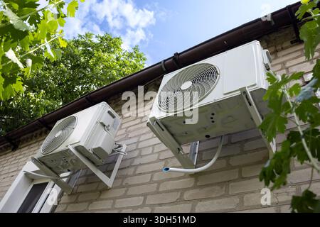 Outdoor two split air conditioning units mounted on siding wall. Stock Photo