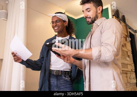 Two coworkers are collaborating in a contemporary coworking space, engrossed in reviewing documents and digital content to brainstorm new ideas for th Stock Photo