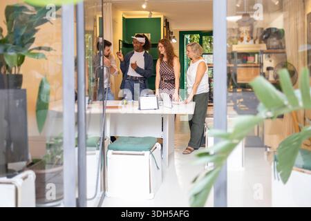 A diverse group of coworkers engaging in a collaborative discussion in a modern coworking space, highlighting teamwork, creativity, and innovation in Stock Photo