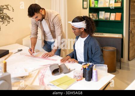A creative team collaborates in a modern coworking space, focusing on a design project. The atmosphere is vibrant and conducive to innovative work, pr Stock Photo